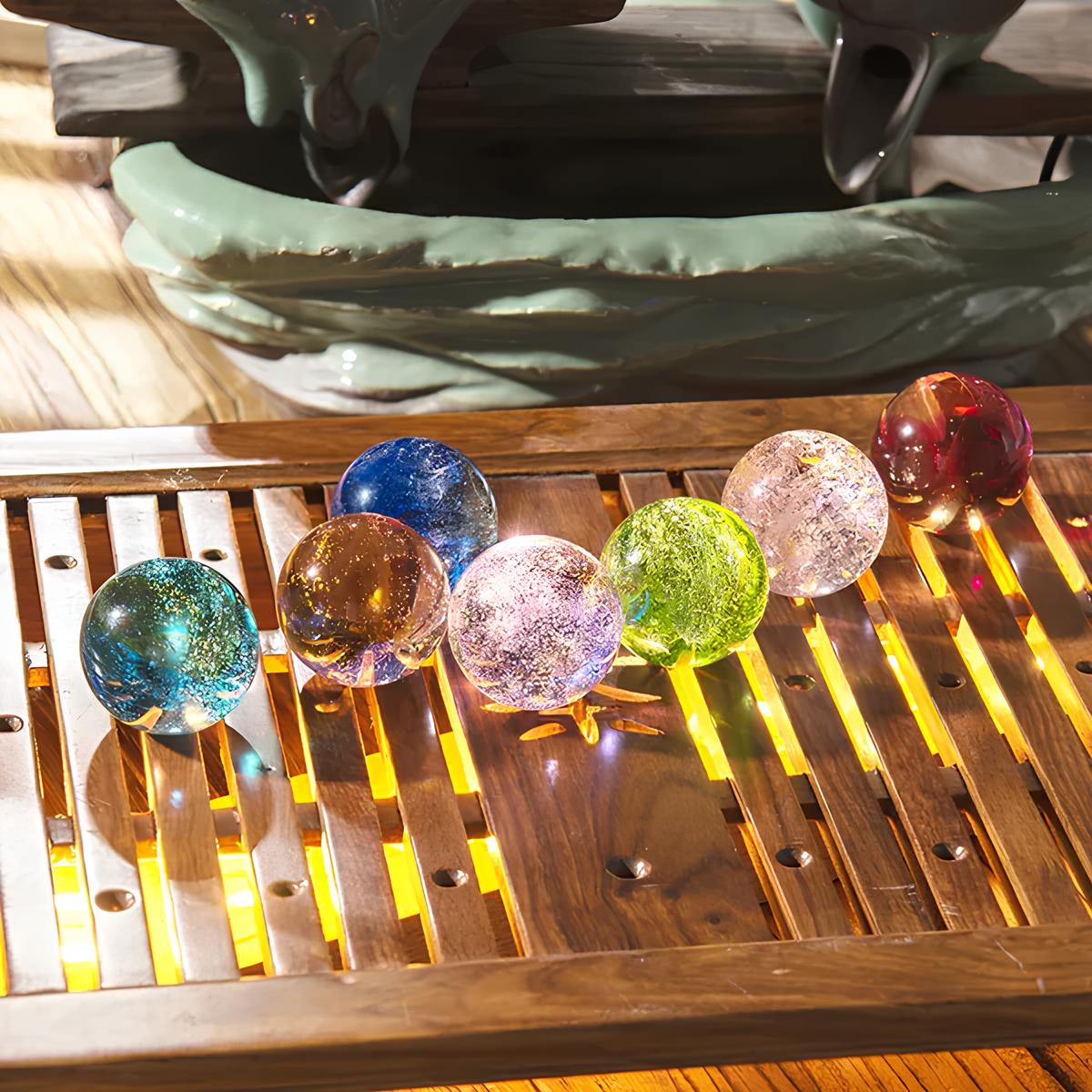 Set aus 7 leuchtenden Kristallkugeln mit Galaxie-Motiven auf Holzsockel
