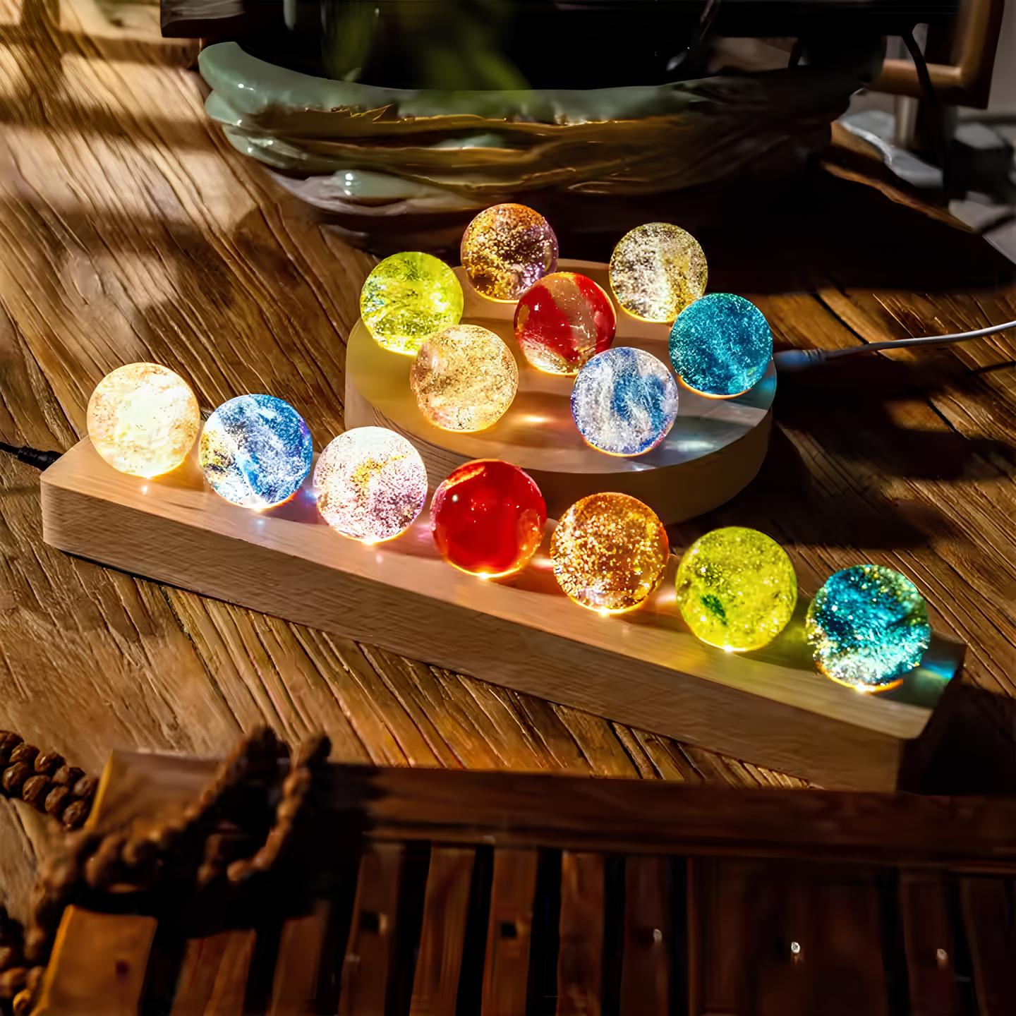 Set aus 7 leuchtenden Kristallkugeln mit Galaxie-Motiven auf Holzsockel